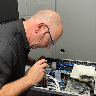 Technician examining internal wiring and electronic components during fault diagnosis